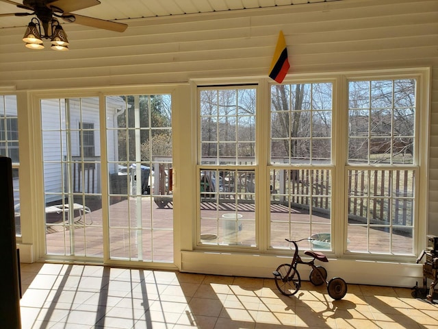 unfurnished sunroom featuring ceiling fan