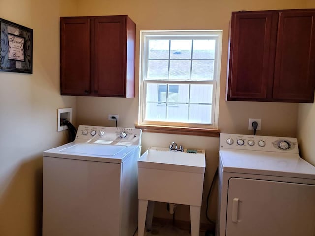 clothes washing area with washing machine and dryer, cabinet space, and a sink