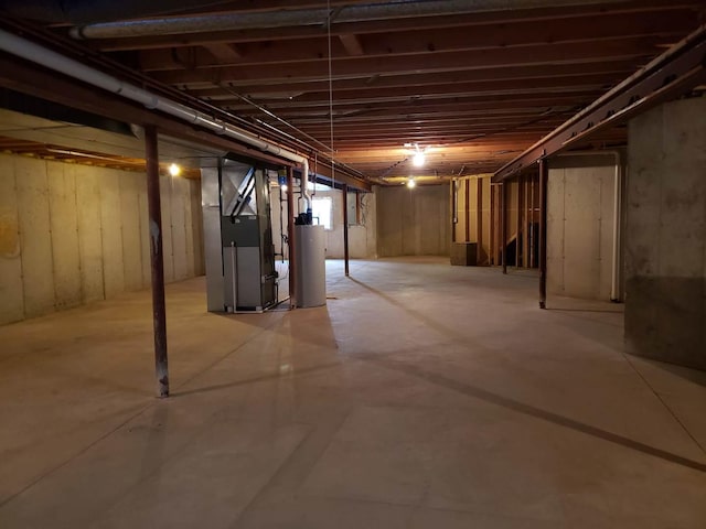 unfinished below grade area featuring gas water heater and heating unit