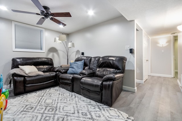 living area with ceiling fan, baseboards, and wood finished floors