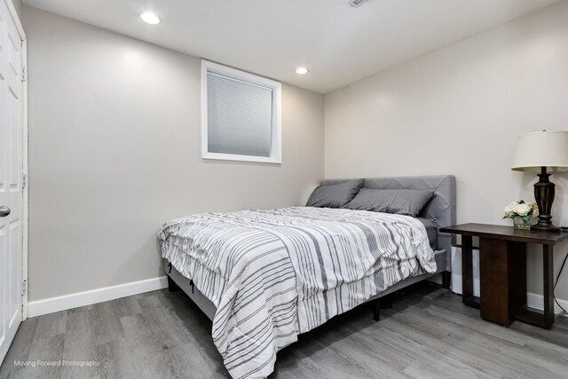 bedroom with recessed lighting, baseboards, and wood finished floors