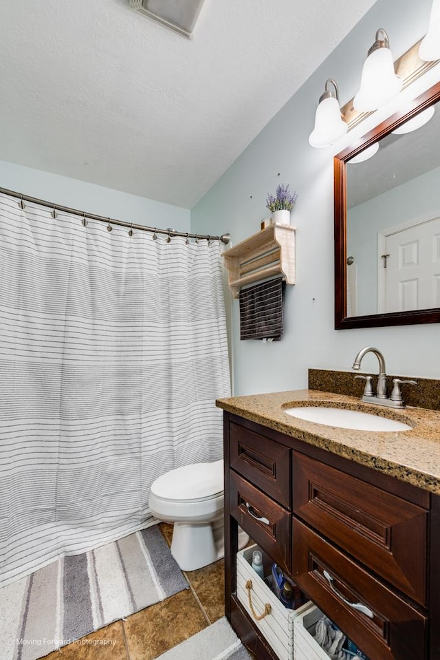 bathroom featuring a textured ceiling, a shower with shower curtain, vanity, and toilet