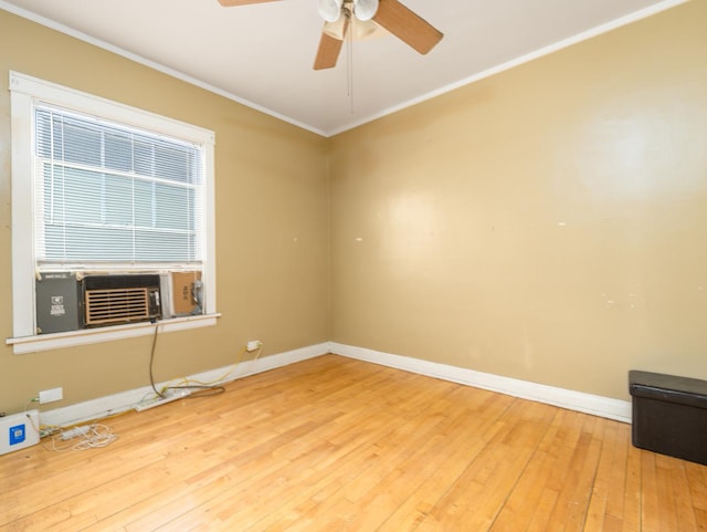 empty room featuring crown molding, baseboards, and hardwood / wood-style floors