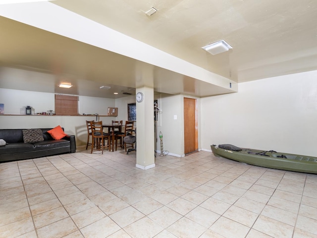 living area featuring light tile patterned floors and baseboards