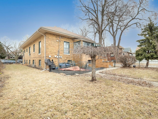 back of house with brick siding and fence