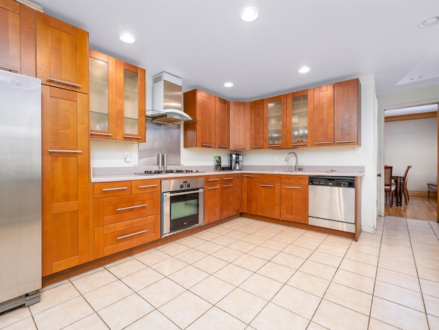 kitchen with recessed lighting, appliances with stainless steel finishes, brown cabinetry, light countertops, and extractor fan