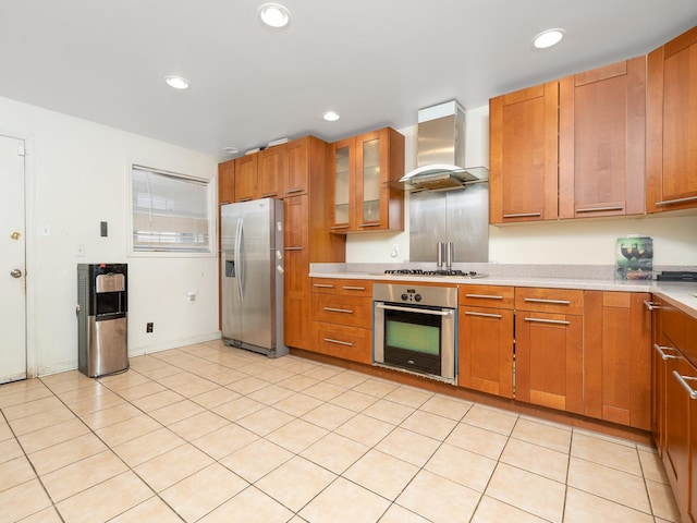 kitchen with brown cabinets, wall chimney range hood, recessed lighting, stainless steel appliances, and light countertops