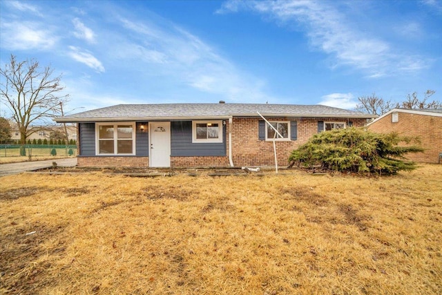 ranch-style house with a front yard and brick siding