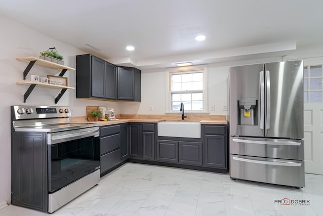 kitchen featuring marble finish floor, appliances with stainless steel finishes, light countertops, and a sink