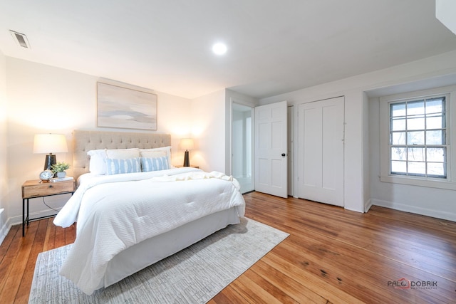 bedroom featuring visible vents, baseboards, and hardwood / wood-style flooring