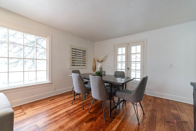 dining room featuring french doors, hardwood / wood-style floors, and baseboards