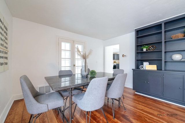 dining room featuring dark wood-style flooring, visible vents, and baseboards