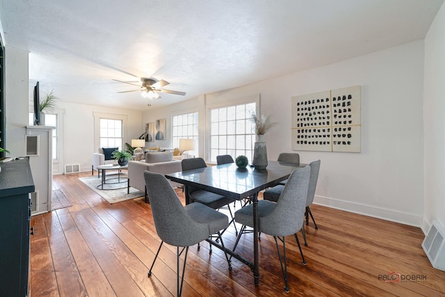 dining space featuring baseboards, visible vents, ceiling fan, and hardwood / wood-style floors