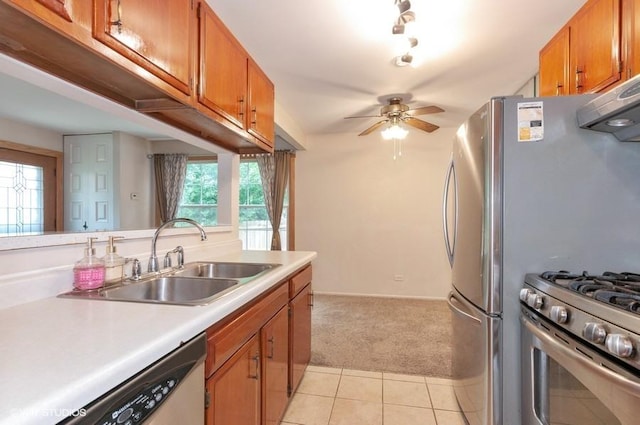 kitchen featuring brown cabinets, stainless steel appliances, light countertops, and a sink