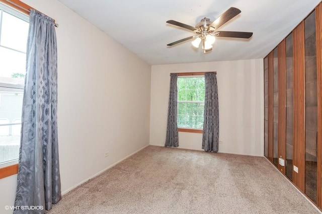 carpeted spare room featuring a ceiling fan