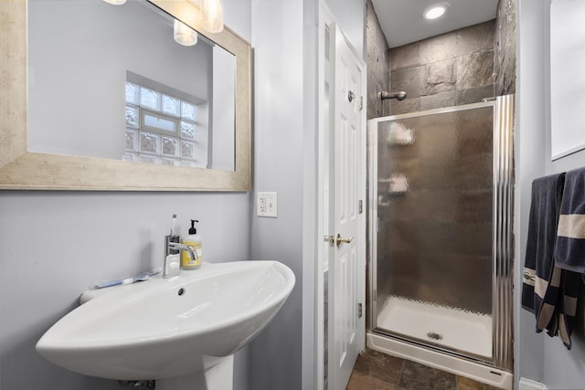 bathroom featuring a sink and a shower stall