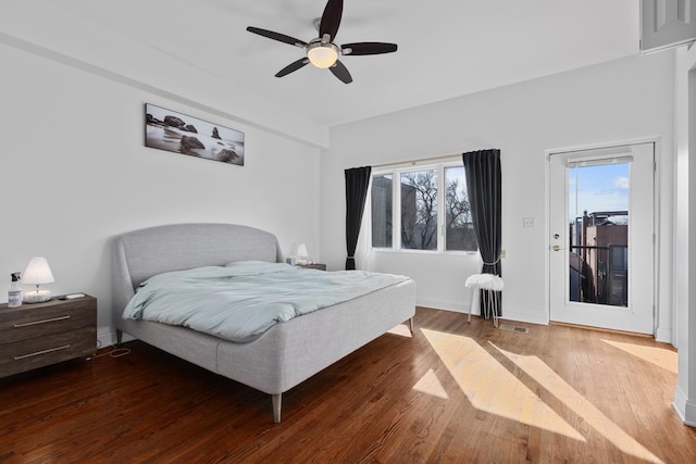 bedroom featuring access to outside, wood finished floors, a ceiling fan, and baseboards