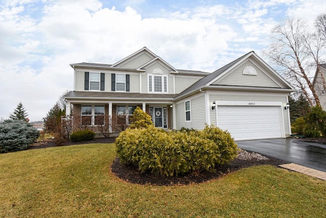 traditional-style house featuring a garage, driveway, and a front lawn