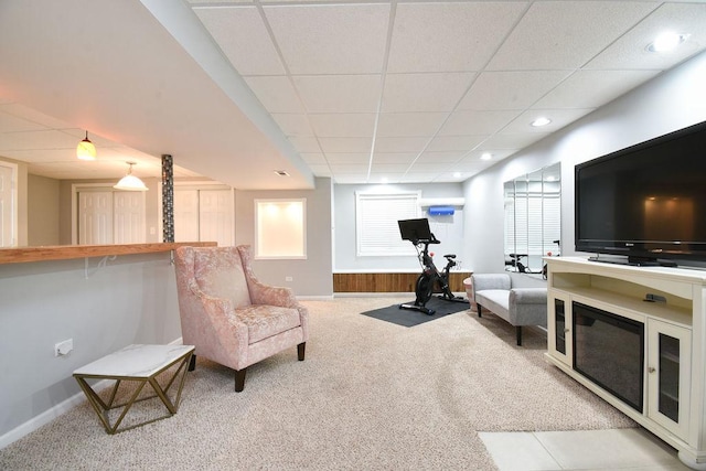 living area with baseboards, carpet flooring, and a drop ceiling