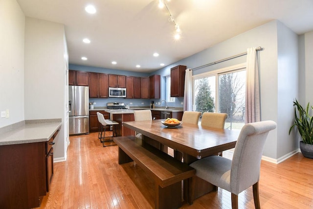 dining room featuring baseboards, track lighting, light wood-type flooring, and recessed lighting