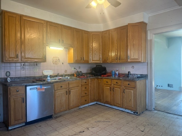 kitchen featuring dishwasher, light floors, and dark countertops