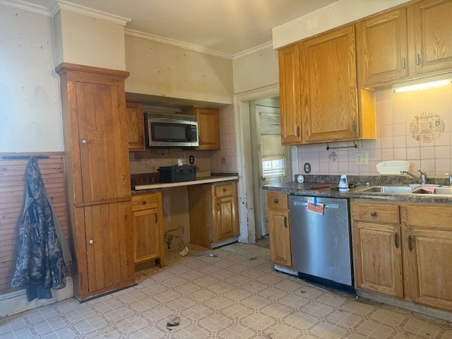 kitchen with stainless steel appliances, brown cabinetry, crown molding, and a sink