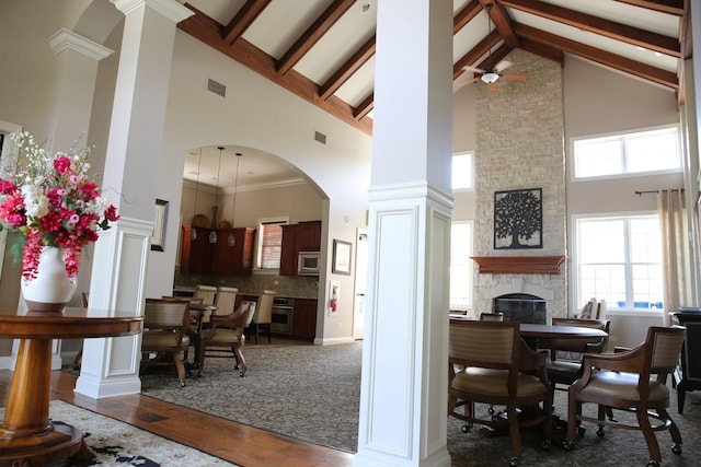 1623 Colchester Ln, Aurora, IL 60505 - dining room with high vaulted ceiling, a fireplace, wood finished floors, ornate columns, and arched walkways