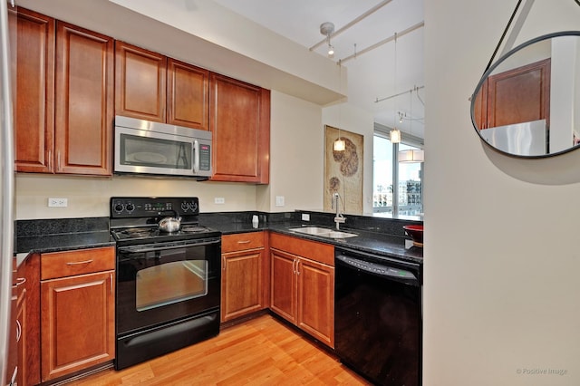 1841 S Calumet Ave Unit 1008, Chicago, IL 60616 - kitchen featuring black appliances, a sink, light wood finished floors, rail lighting, and dark stone countertops