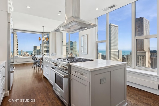 kitchen with dark wood-type flooring, high end stove, visible vents, and island range hood