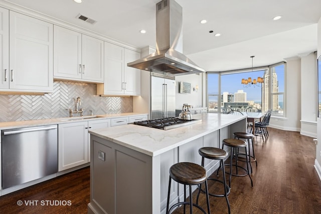 kitchen featuring visible vents, island exhaust hood, a sink, white cabinets, and appliances with stainless steel finishes