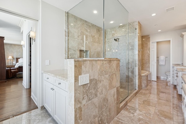 ensuite bathroom with visible vents, marble finish floor, a stall shower, and toilet