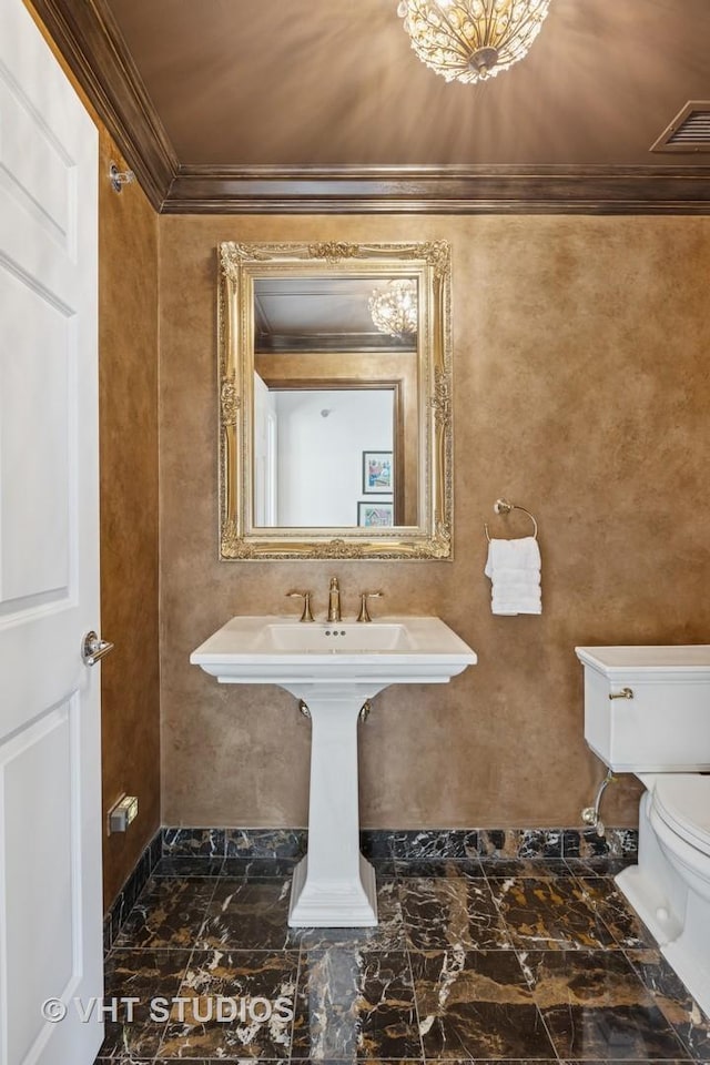 half bathroom with visible vents, marble finish floor, toilet, and crown molding