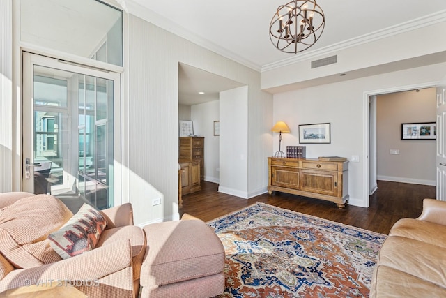 living room featuring visible vents, ornamental molding, wood finished floors, an inviting chandelier, and baseboards