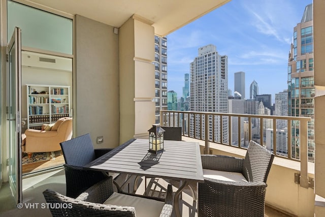 balcony featuring a view of city and outdoor dining space