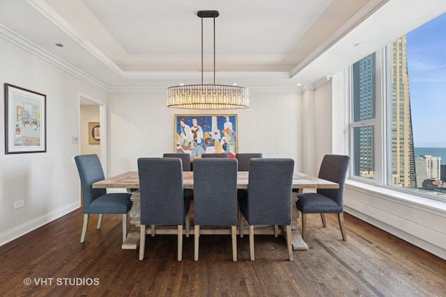 dining space featuring a tray ceiling, baseboards, ornamental molding, and dark wood-style flooring