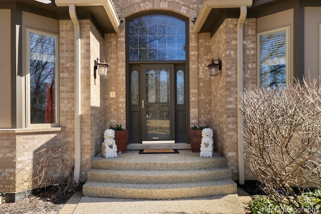 doorway to property featuring brick siding