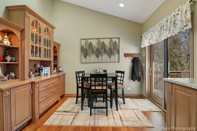 dining space with light wood finished floors, recessed lighting, baseboards, and lofted ceiling