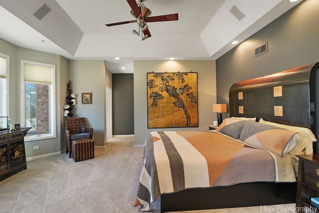 bedroom with visible vents, baseboards, a tray ceiling, and carpet floors