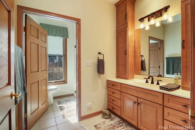 bathroom with tile patterned flooring, toilet, vanity, and baseboards