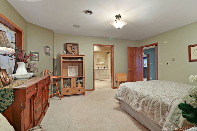 bedroom with a sink, visible vents, light colored carpet, and connected bathroom