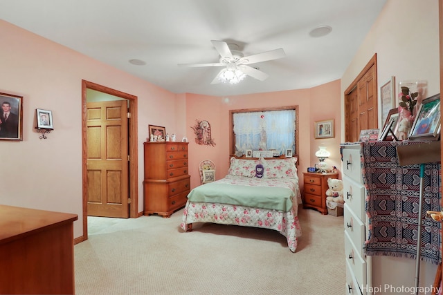 bedroom featuring light colored carpet and a ceiling fan