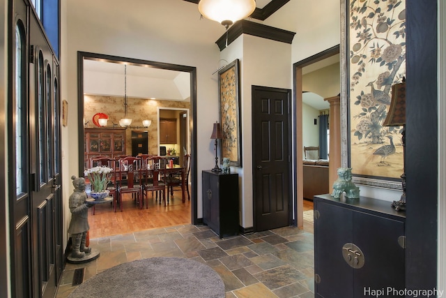 entryway featuring decorative columns and stone tile flooring