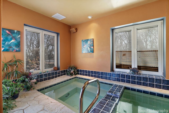 view of pool with an indoor hot tub