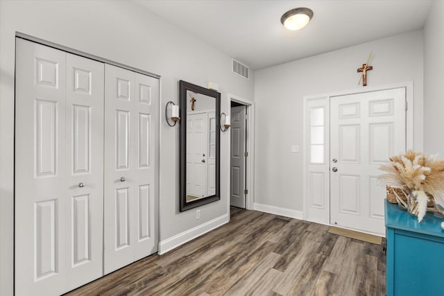 foyer featuring visible vents, baseboards, and wood finished floors