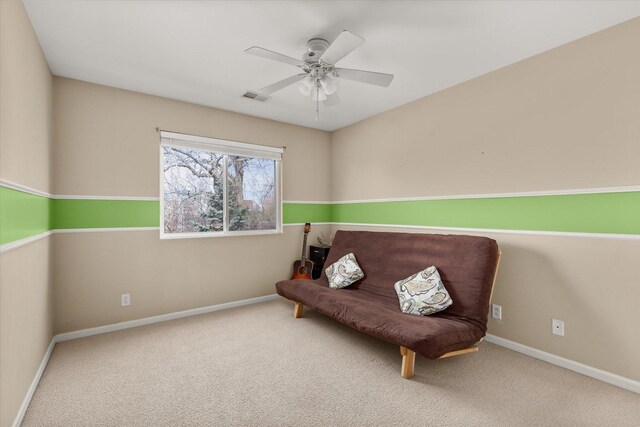 sitting room with visible vents, carpet flooring, baseboards, and ceiling fan