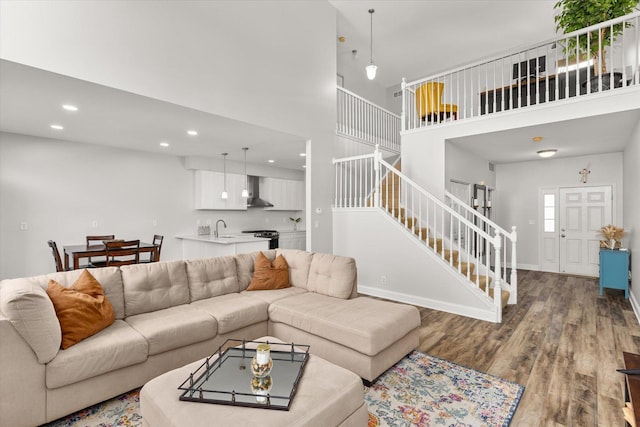 living room with baseboards, stairs, a high ceiling, and wood finished floors