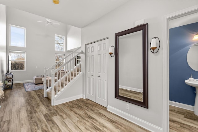 foyer featuring stairs, wood finished floors, and baseboards