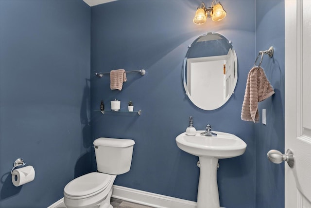 bathroom featuring toilet and baseboards