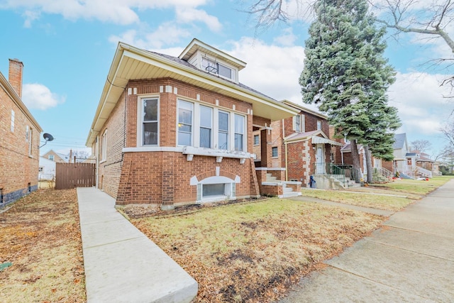 view of front of home featuring brick siding and fence