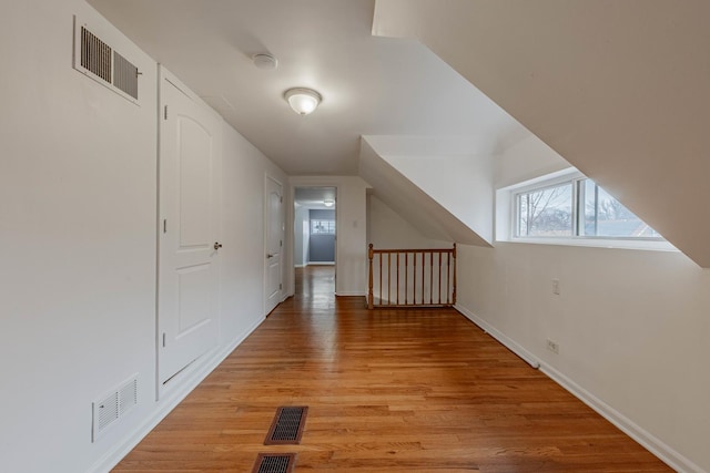 additional living space featuring baseboards, visible vents, and light wood finished floors